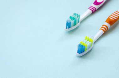 İki diş fırçaları pastel mavi bir arka plan üzerinde yalan. Üstten görünüm, düz yatıyordu. En az kavramı.