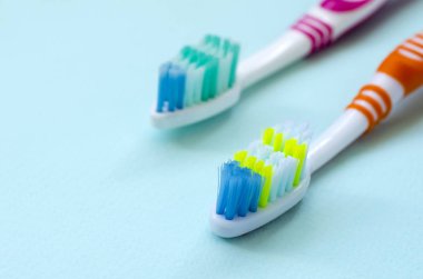 İki diş fırçaları pastel mavi bir arka plan üzerinde yalan. Üstten görünüm, düz yatıyordu. En az kavramı.