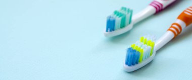 İki diş fırçaları pastel mavi bir arka plan üzerinde yalan. Üstten görünüm, düz yatıyordu. En az kavramı.