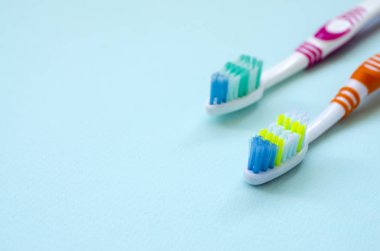 İki diş fırçaları pastel mavi bir arka plan üzerinde yalan. Üstten görünüm, düz yatıyordu. En az kavramı.