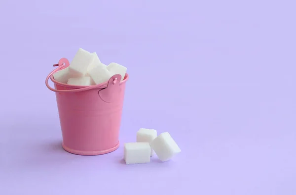 Egy Miniatűr Rózsaszín Vödör Tele Kocka Cukrot Fekszik Pasztell Lila — Stock Fotó
