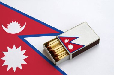 Nepal bayrağı açık bir kibrit kutusu içinde gösterilen hangi dolu maçlar ve büyük bir bayrak üzerinde yatıyor.