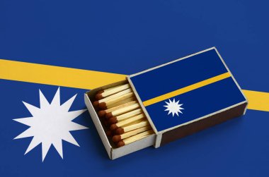 Nauru bayrak açık bir kibrit kutusu içinde gösterilen hangi dolu maçlar ve büyük bir bayrak üzerinde yatıyor.