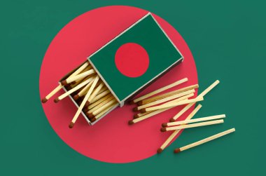 Bangladeş bayrağı bir kibrit kutusu içinden birkaç sonbahar eşleşir ve büyük bir bayrak üzerinde yatıyor açık gösterilir.