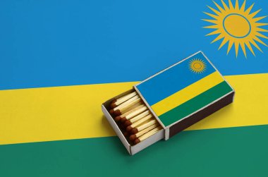 Ruanda bayrak açık bir kibrit kutusu içinde gösterilen hangi dolu maçlar ve büyük bir bayrak üzerinde yatıyor.
