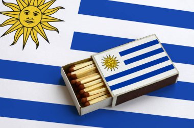 Uruguay bayrağı açık bir kibrit kutusu içinde gösterilen hangi dolu maçlar ve büyük bir bayrak üzerinde yatıyor.