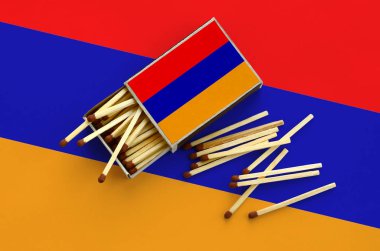 Ermenistan bayrağı bir kibrit kutusu içinden birkaç sonbahar eşleşir ve büyük bir bayrak üzerinde yatıyor açık gösterilir.