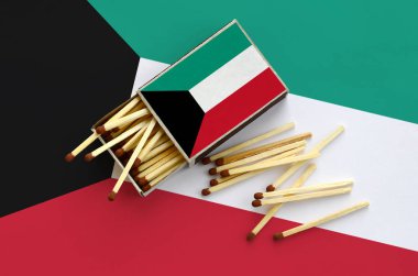 Kuveyt bayrağı bir kibrit kutusu içinden birkaç sonbahar eşleşir ve büyük bir bayrak üzerinde yatıyor açık gösterilir.