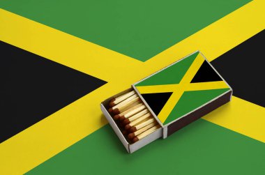Jamaika bayrağını açık bir kibrit kutusu içinde gösterilen hangi dolu maçlar ve büyük bir bayrak üzerinde yatıyor.