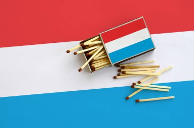 Lüksemburg bayrağı bir kibrit kutusu içinden birkaç sonbahar eşleşir ve büyük bir bayrak üzerinde yatıyor açık gösterilir.