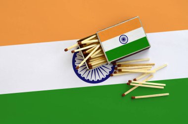 Hindistan bayrağı bir kibrit kutusu içinden birkaç sonbahar eşleşir ve büyük bir bayrak üzerinde yatıyor açık gösterilir.