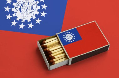 Myanmar bayrağı açık bir kibrit kutusu içinde gösterilen hangi dolu maçlar ve büyük bir bayrak üzerinde yatıyor.