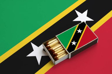 Saint Kitts ve Nevis bayrak açık bir kibrit kutusu içinde gösterilen hangi dolu maçlar ve büyük bir bayrak üzerinde yatıyor.