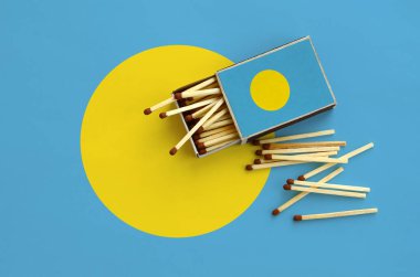 Palau bayrak bir kibrit kutusu içinden birkaç sonbahar eşleşir ve büyük bir bayrak üzerinde yatıyor açık gösterilir.