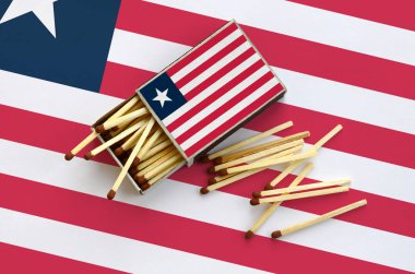 Liberya bayrağı bir kibrit kutusu içinden birkaç sonbahar eşleşir ve büyük bir bayrak üzerinde yatıyor açık gösterilir.