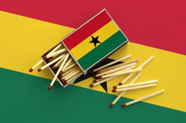 Gana bayrak bir kibrit kutusu içinden birkaç sonbahar eşleşir ve büyük bir bayrak üzerinde yatıyor açık gösterilir.