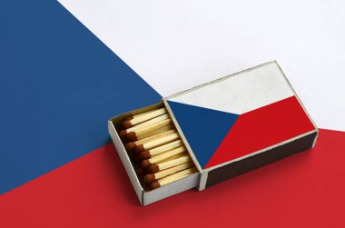 Çek bayrak açık bir kibrit kutusu içinde gösterilen hangi dolu maçlar ve büyük bir bayrak üzerinde yatıyor.