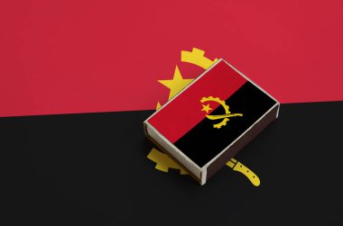 Angola bayrağı üzerinde büyük bir bayrak yatıyor bir kibrit kutusu üzerinde resimde.