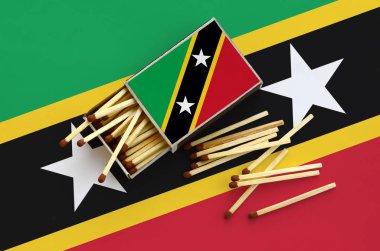 Saint Kitts ve Nevis bayrak bir kibrit kutusu içinden birkaç sonbahar eşleşir ve büyük bir bayrak üzerinde yatıyor açık gösterilir.