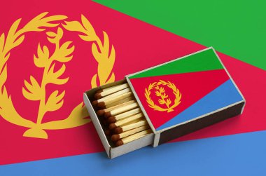 Eritre bayrak açık bir kibrit kutusu içinde gösterilen hangi dolu maçlar ve büyük bir bayrak üzerinde yatıyor.