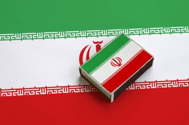 Iran bayrağı üzerinde büyük bir bayrak yatıyor bir kibrit kutusu üzerinde resimde.