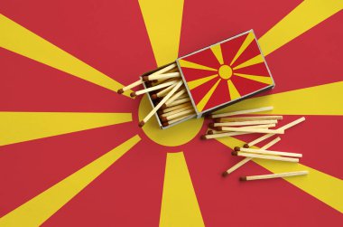 Makedonya bayrak bir kibrit kutusu içinden birkaç sonbahar eşleşir ve büyük bir bayrak üzerinde yatıyor açık gösterilir.
