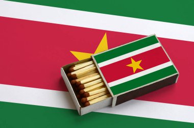 Surinam bayrak açık bir kibrit kutusu içinde gösterilen hangi dolu maçlar ve büyük bir bayrak üzerinde yatıyor.