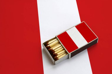 Peru bayrağı açık bir kibrit kutusu içinde gösterilen hangi dolu maçlar ve büyük bir bayrak üzerinde yatıyor.