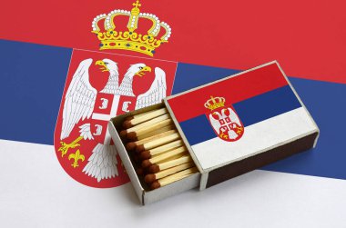 Sırbistan bayrağı açık bir kibrit kutusu içinde gösterilen hangi dolu maçlar ve büyük bir bayrak üzerinde yatıyor.