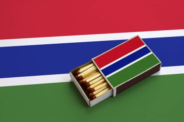 Gambiya bayrak açık bir kibrit kutusu içinde gösterilen hangi dolu maçlar ve büyük bir bayrak üzerinde yatıyor.