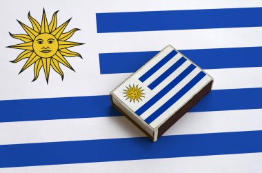 Uruguay bayrağı üzerinde büyük bir bayrak yatıyor bir kibrit kutusu üzerinde resimde.