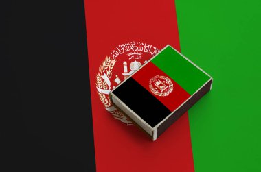 Afganistan bayrağı üzerinde büyük bir bayrak yatıyor bir kibrit kutusu üzerinde resimde.