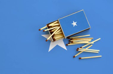 Somali bayrağı bir kibrit kutusu içinden birkaç sonbahar eşleşir ve büyük bir bayrak üzerinde yatıyor açık gösterilir.