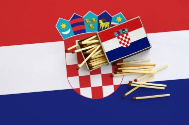 Hırvatistan bayrağı bir kibrit kutusu içinden birkaç sonbahar eşleşir ve büyük bir bayrak üzerinde yatıyor açık gösterilir.