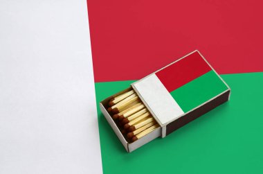 Madagaskar bayrağı açık bir kibrit kutusu içinde gösterilen hangi dolu maçlar ve büyük bir bayrak üzerinde yatıyor.