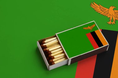 Zambiya bayrağı açık bir kibrit kutusu içinde gösterilen hangi dolu maçlar ve büyük bir bayrak üzerinde yatıyor.