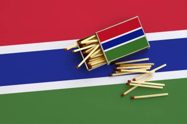 Gambiya bayrak bir kibrit kutusu içinden birkaç sonbahar eşleşir ve büyük bir bayrak üzerinde yatıyor açık gösterilir.