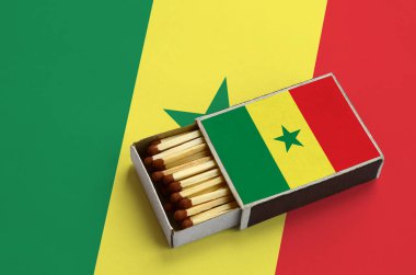 Senegal bayrak açık bir kibrit kutusu içinde gösterilen hangi dolu maçlar ve büyük bir bayrak üzerinde yatıyor.
