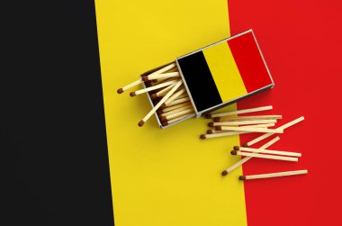 Belçika bayrağı bir kibrit kutusu içinden birkaç sonbahar eşleşir ve büyük bir bayrak üzerinde yatıyor açık gösterilir.