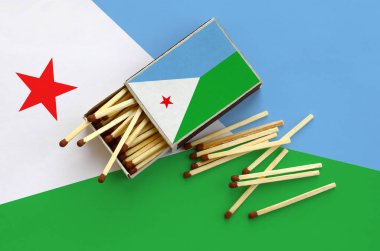 Cibuti bayrağı bir kibrit kutusu içinden birkaç sonbahar eşleşir ve büyük bir bayrak üzerinde yatıyor açık gösterilir.