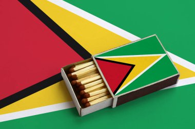 Guyana bayrak açık bir kibrit kutusu içinde gösterilen hangi dolu maçlar ve büyük bir bayrak üzerinde yatıyor.