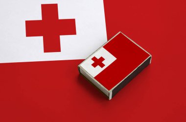 Tonga bayrağı üzerinde büyük bir bayrak yatıyor bir kibrit kutusu üzerinde resimde.