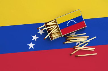 Venezuela bayrak bir kibrit kutusu içinden birkaç sonbahar eşleşir ve büyük bir bayrak üzerinde yatıyor açık gösterilir.