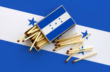 Honduras bayrağı bir kibrit kutusu içinden birkaç sonbahar eşleşir ve büyük bir bayrak üzerinde yatıyor açık gösterilir.