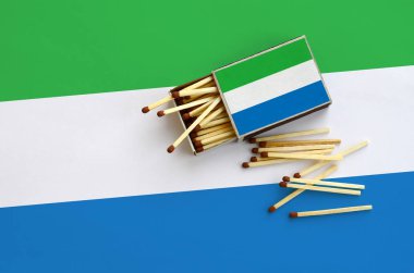 Sierra Leone bayrak bir kibrit kutusu içinden birkaç sonbahar eşleşir ve büyük bir bayrak üzerinde yatıyor açık gösterilir.