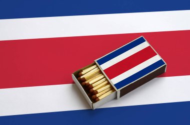 Kosta Rika bayrak açık bir kibrit kutusu içinde gösterilen hangi dolu maçlar ve büyük bir bayrak üzerinde yatıyor.