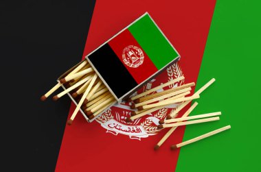 Afganistan bayrağı bir kibrit kutusu içinden birkaç sonbahar eşleşir ve büyük bir bayrak üzerinde yatıyor açık gösterilir.