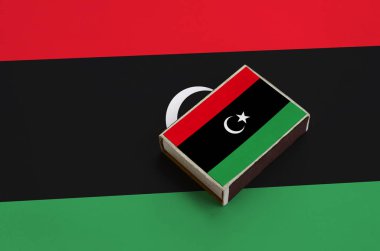 Libya bayrağı üzerinde büyük bir bayrak yatıyor bir kibrit kutusu üzerinde resimde.