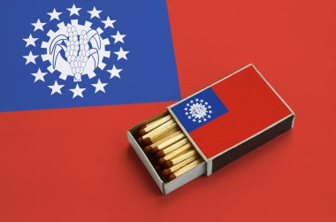Myanmar bayrağı açık bir kibrit kutusu içinde gösterilen hangi dolu maçlar ve büyük bir bayrak üzerinde yatıyor.