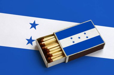 Honduras bayrağı açık bir kibrit kutusu içinde gösterilen hangi dolu maçlar ve büyük bir bayrak üzerinde yatıyor.